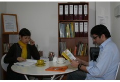 Estudiantes disfrutando de un café y un libro de la biblioteca. 